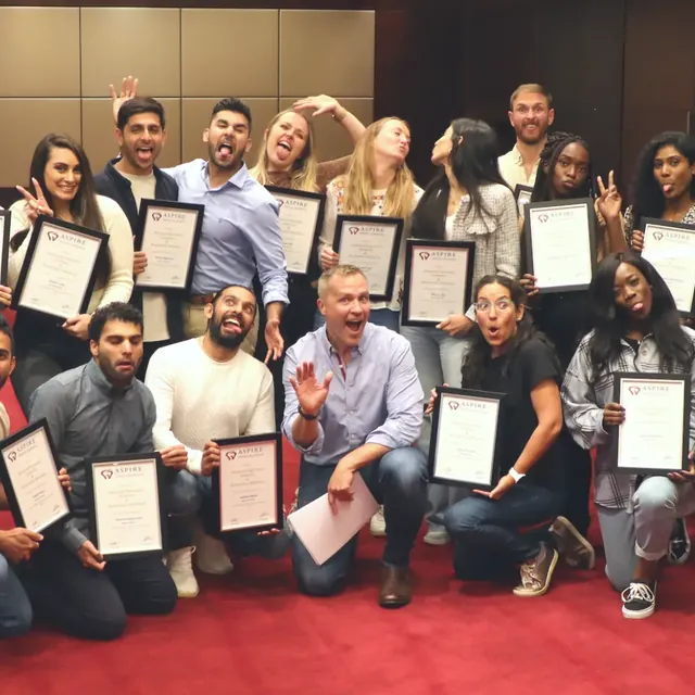 Aspire delegates holding up their course certificates at a graduation evening